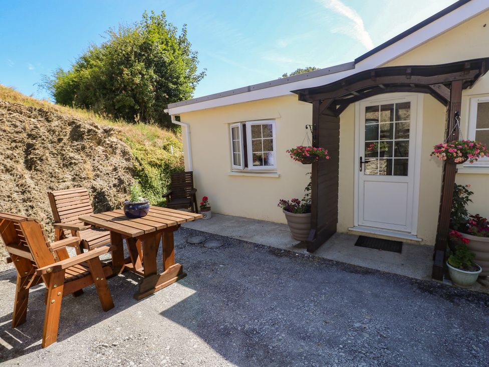 An outdoor seating area with table and chairs at Dolcoed in Manordeilo near Llangadog