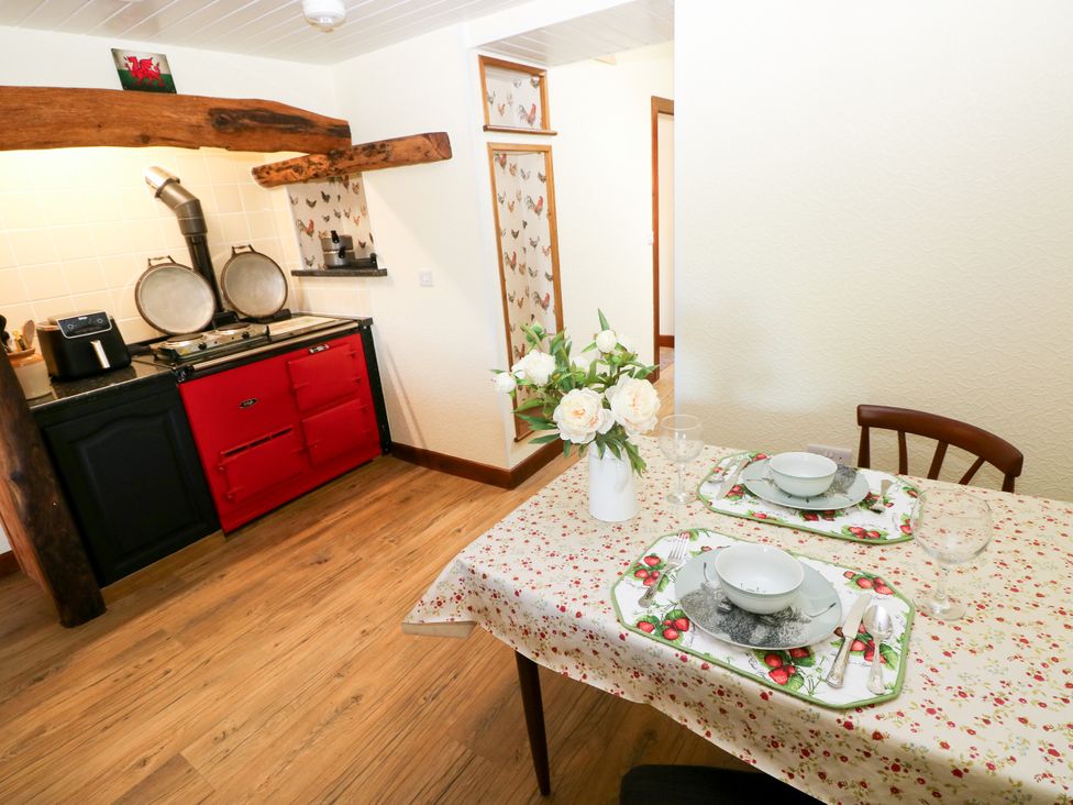 A dining area with a table set in a kitchen at Dolcoed Manordeilo near Llangadog