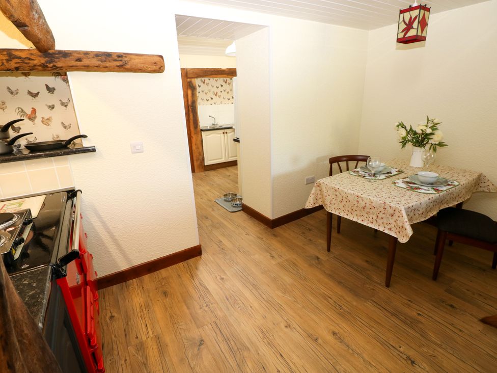 A kitchen with a dining table and stove at Dolcoed Manordeilo near Llangadog