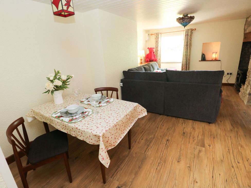 A dining area with a table and a couch at Dolcoed in Manordeilo near Llangadog