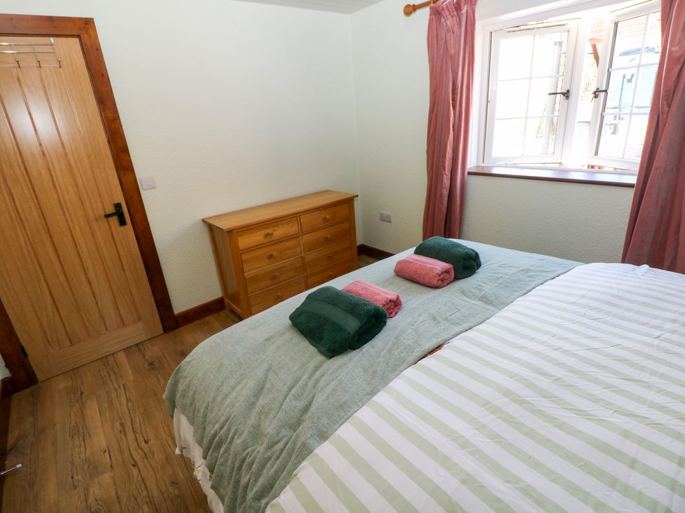 A bedroom with a bed and a dresser at Dolcoed in Manordeilo near Llangadog