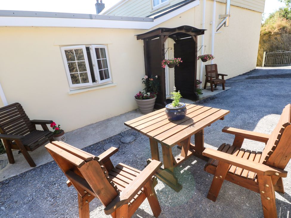An outdoor seating area with wooden chairs and a table at Dolcoed in Manordeilo near Llangadog
