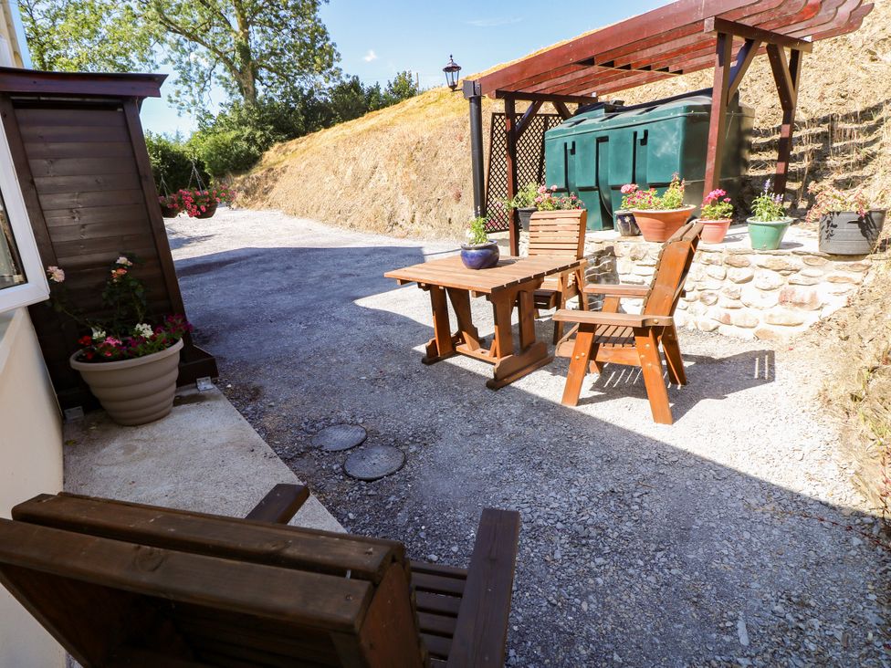An outdoor seating area with a table and chairs at Dolcoed Manordeilo near Llangadog