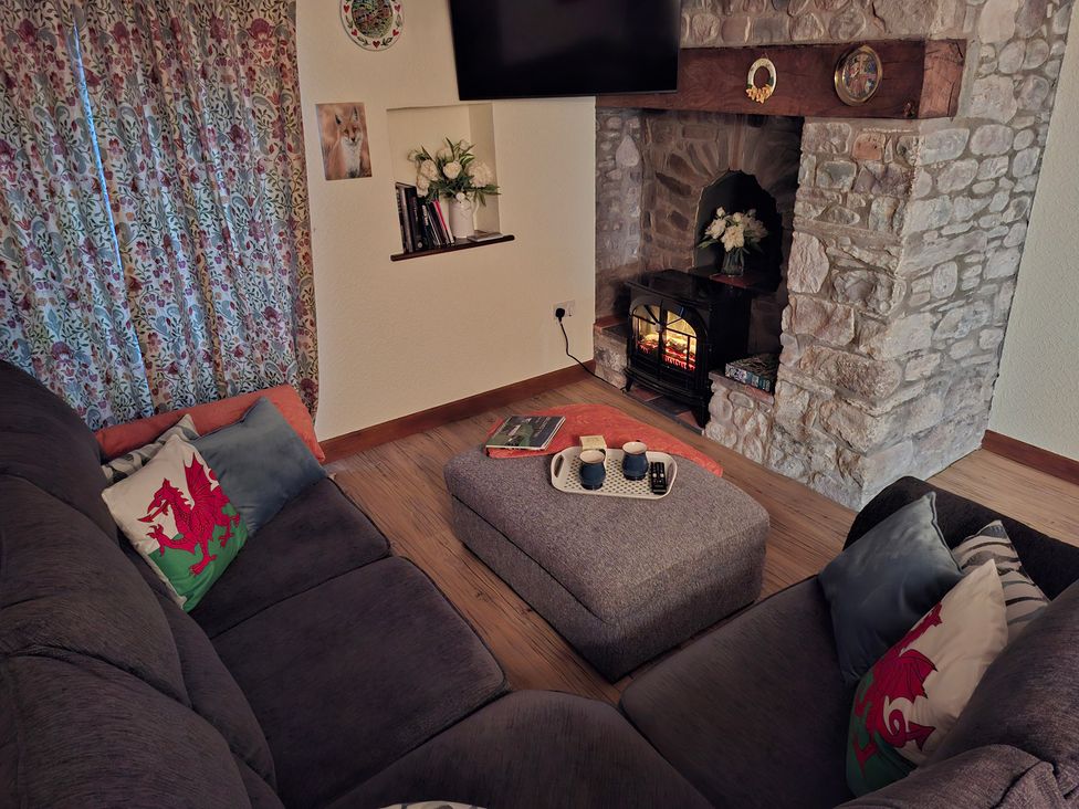 A living room with a sofa and a fireplace at Dolcoed in Llandeilo