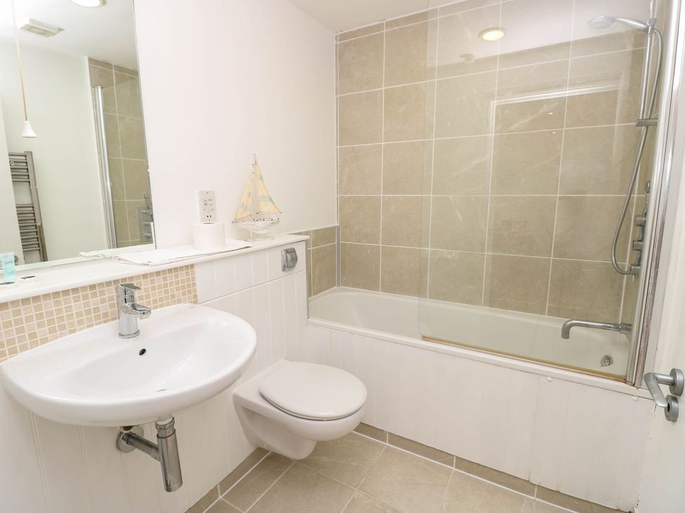 A bathroom with a sink toilet and bathtub with shower at Cape 14 in Yarmouth