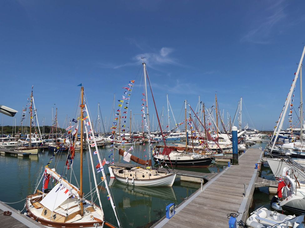 A marina with numerous sailboats docked and decorated with signal flags at Cape 14 in Yarmouth
