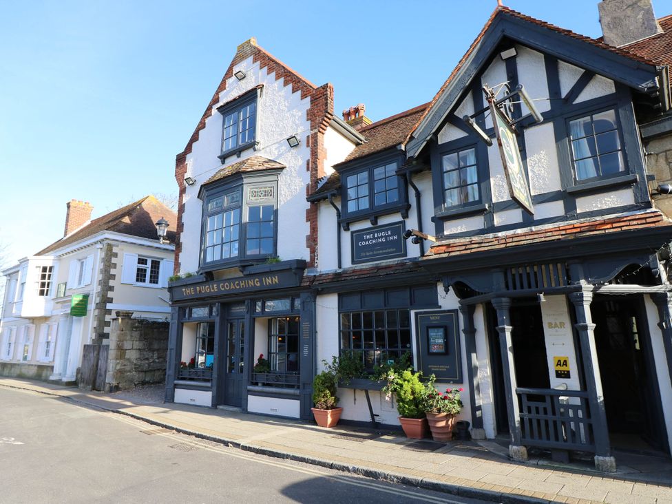 Exterior view of the bugle coaching inn building on a street with potted plants outside