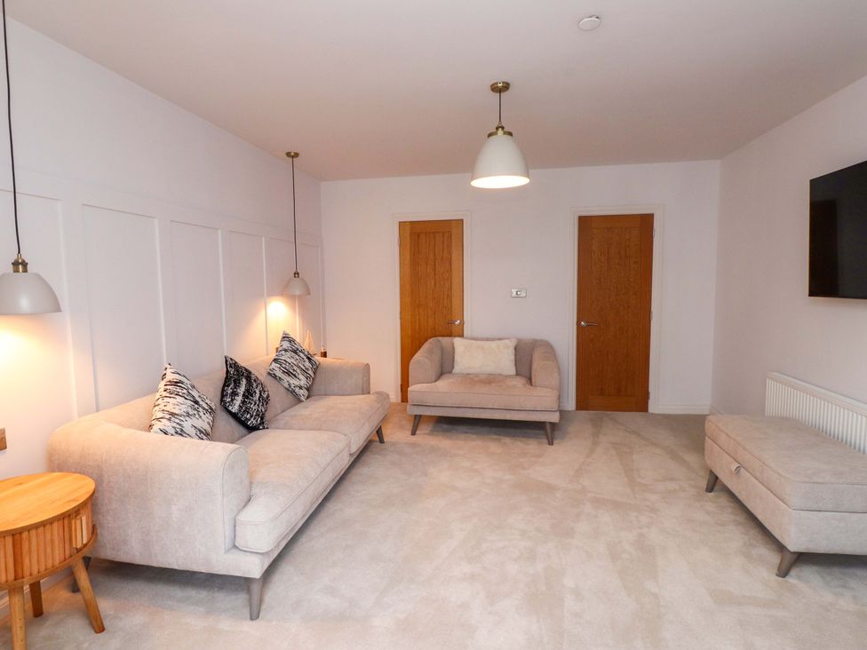 A living room with a sofa and armchair at 5 Lombard Street in Porthmadog