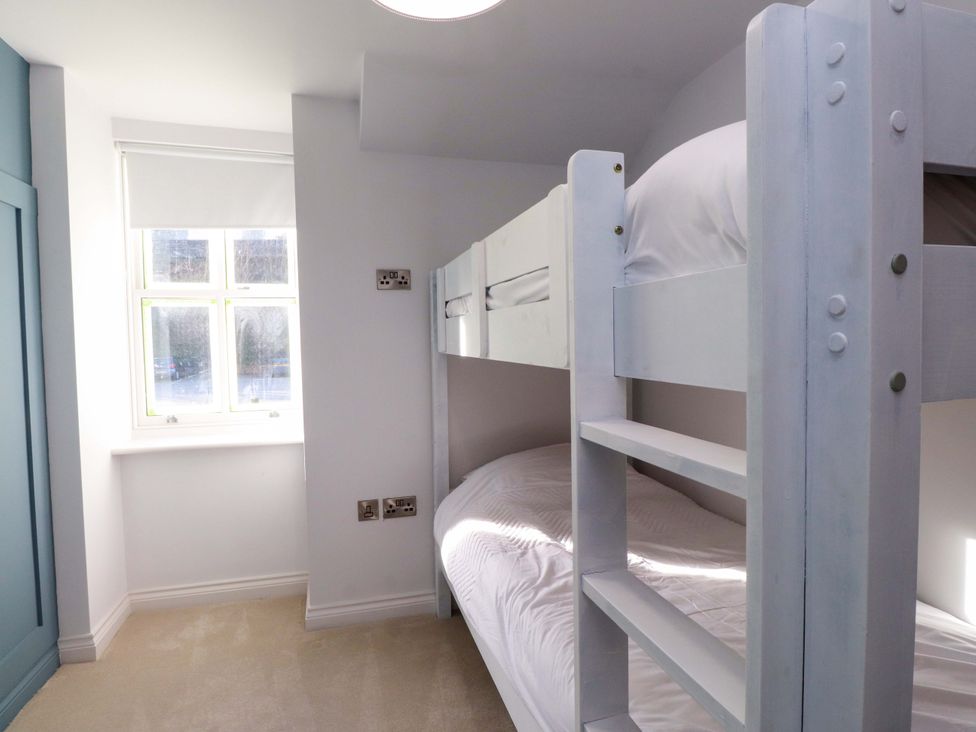 A bedroom with a bunk bed and a window at 5 Lombard Street Porthmadog