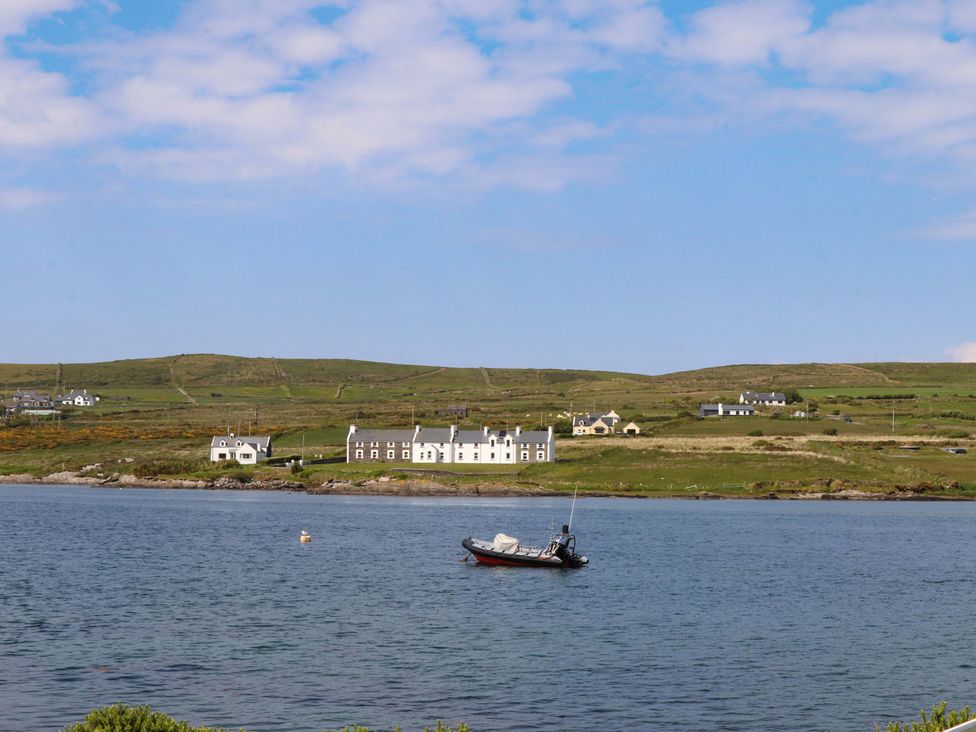 A view of houses and a boat on water at O'Conells Portmagee