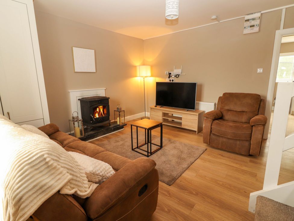 A living room with a fireplace and television at O'Connell's Lodge, Portmagee, County Kerry