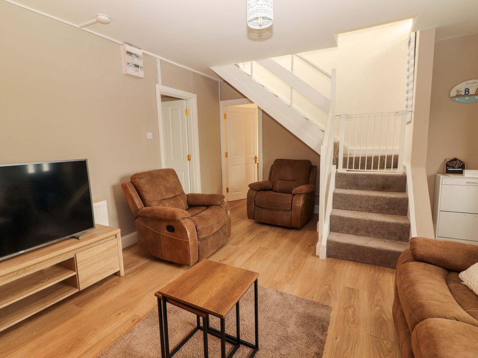 A living room with a TV and seating area at O'Connell's Lodge, Portmagee, County Kerry