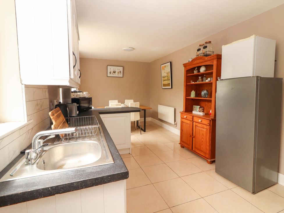 A kitchen with a sink and refrigerator at O'Connell's Lodge, Portmagee, County Kerry