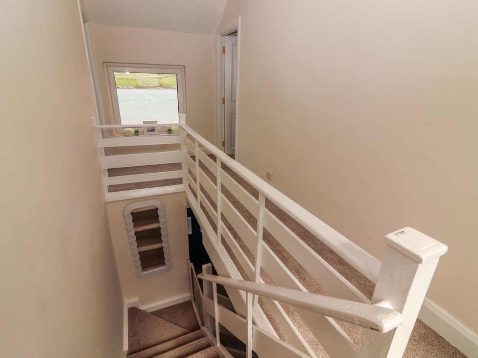 A staircase with railings and a window in a hallway at O'Connell's Lodge, Portmagee, County Kerry