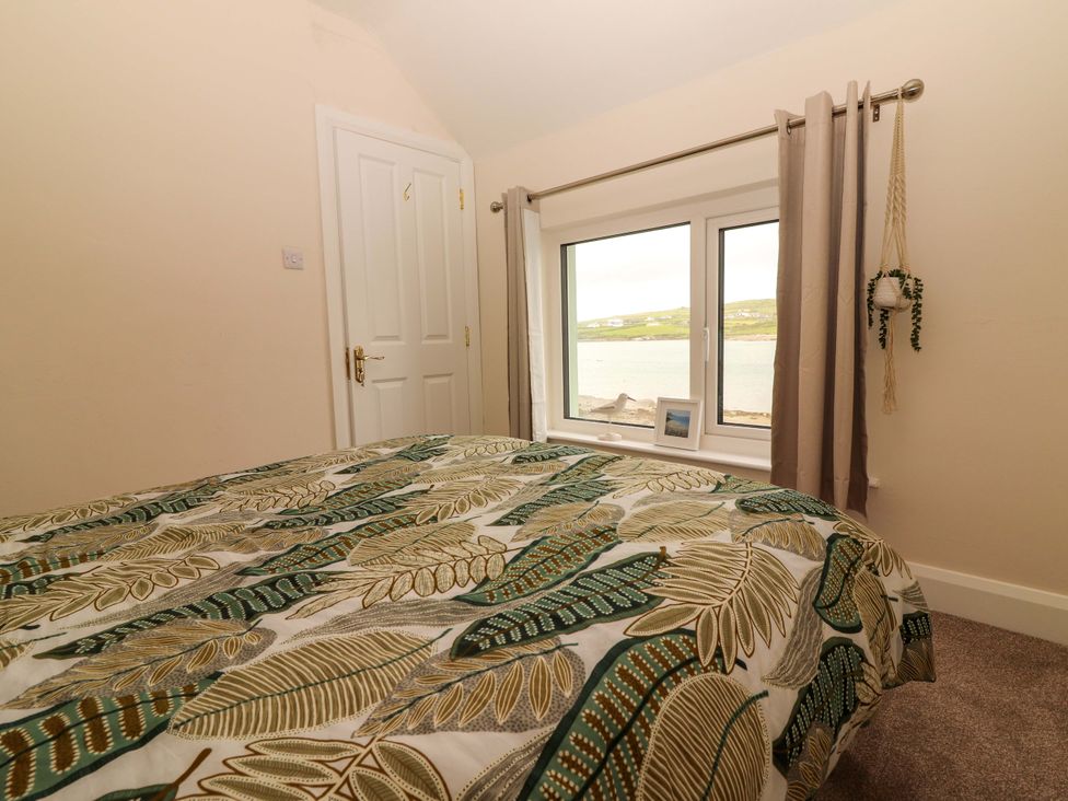 A bedroom with a bed and window at O'Connell's Lodge in Portmagee, County Kerry
