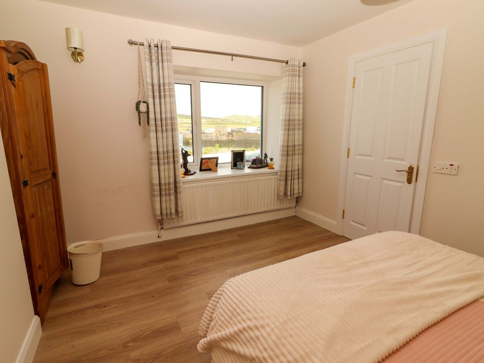 A bedroom with a window and wardrobe at O'Connell's Lodge, Portmagee, County Kerry