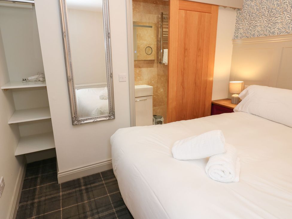 A bedroom with a bed and a bathroom door at Cottage 10 in Brandon, County Durham