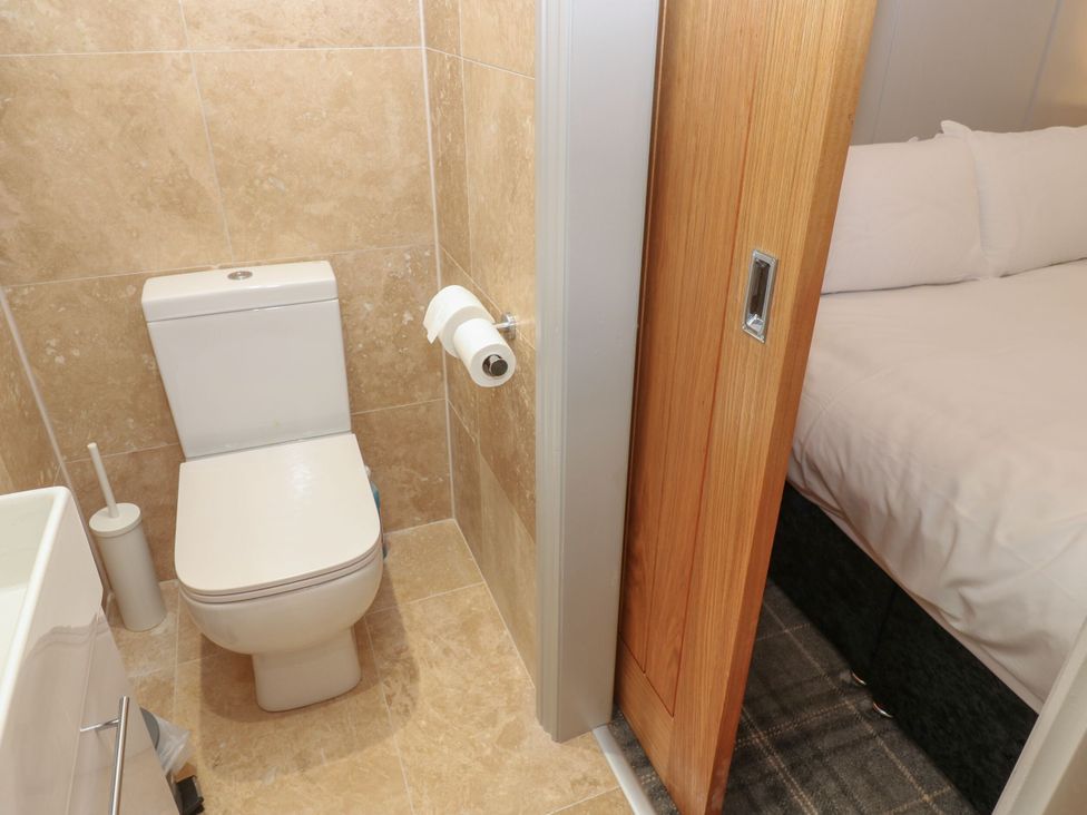 A bathroom with toilet and door leading to a bedroom at Cottage 10 in Brandon, County Durham