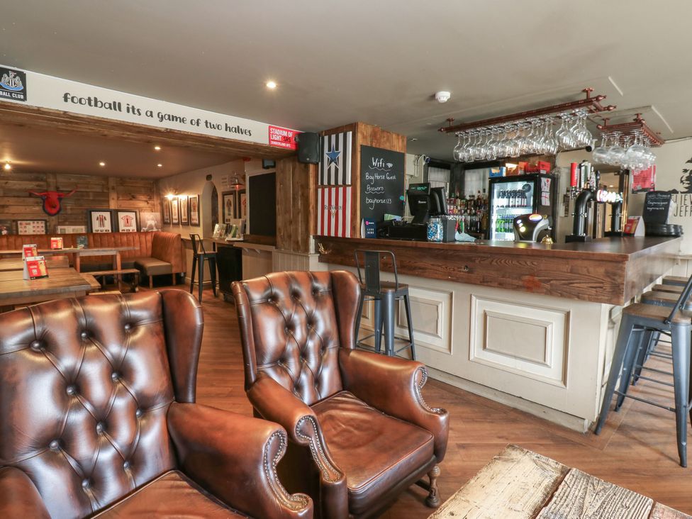 A bar with seating and drinks displayed at Cottage 10 in Brandon, County Durham
