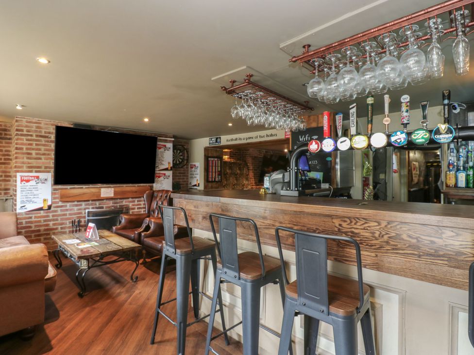 A pub with a bar, stools, and seating area at Cottage 10 in Brandon, County Durham