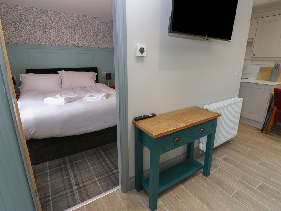 A bedroom with a bed and a console table at Cottage 9 in Brandon, County Durham