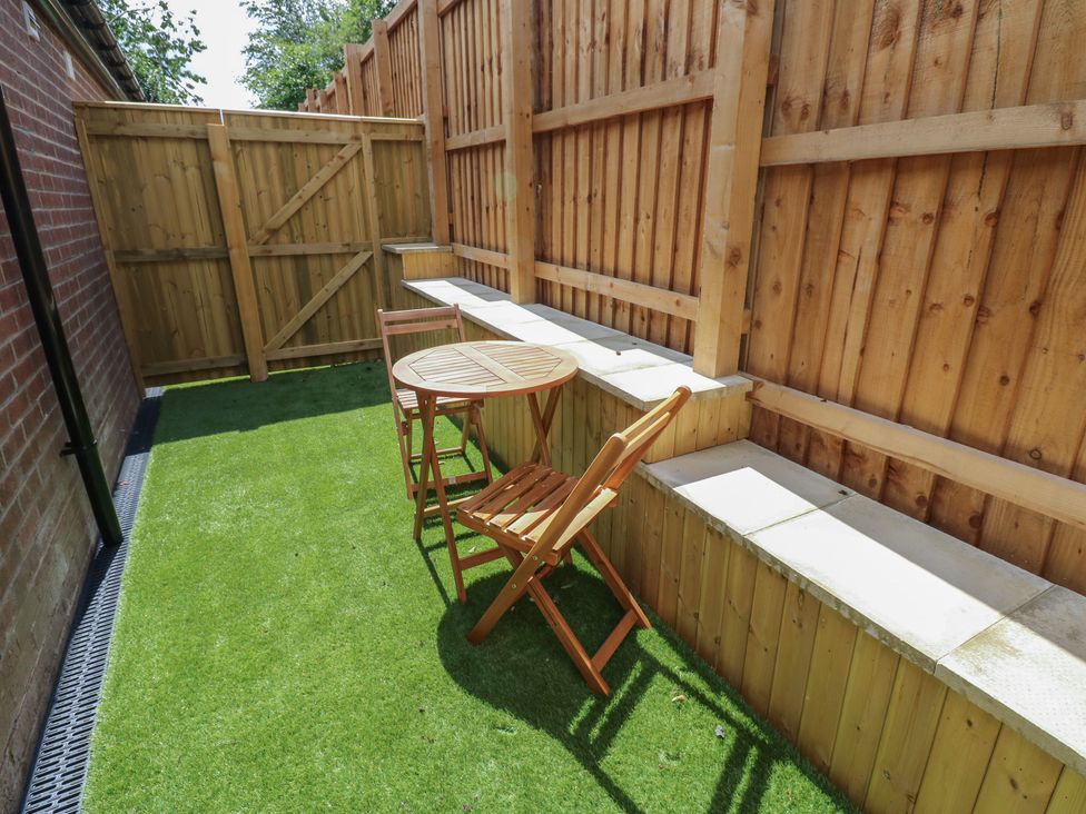 A garden with a wooden table and chair at Cottage 9 in Brandon, County Durham
