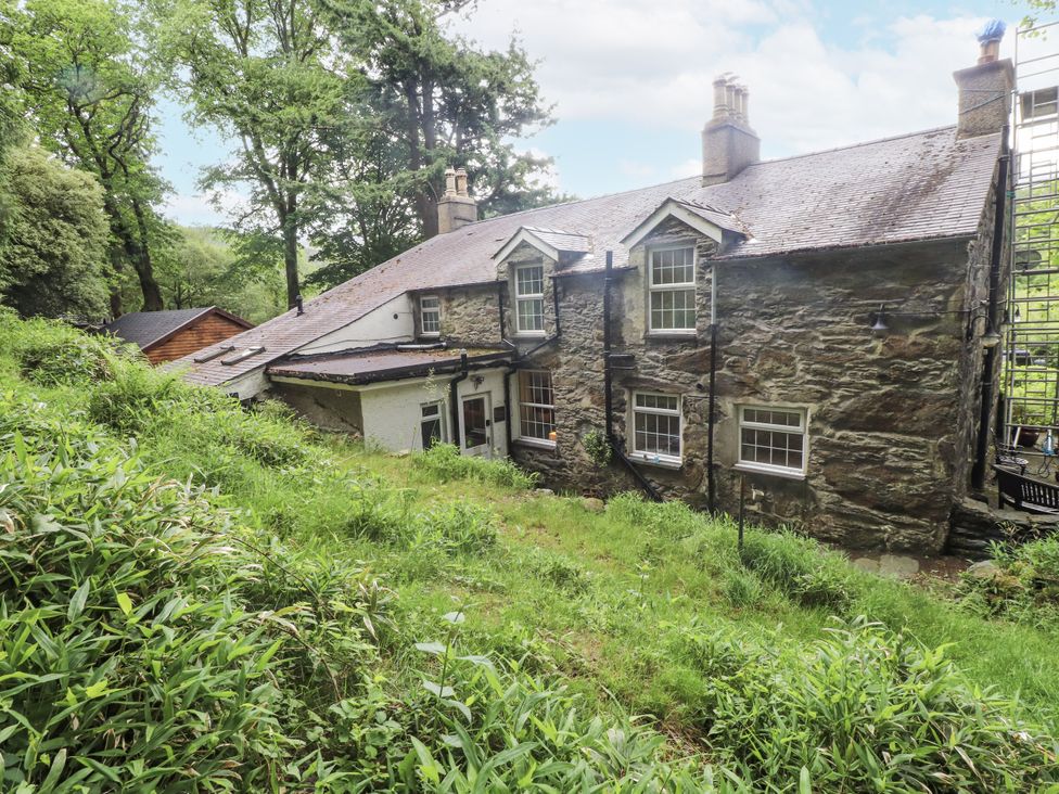 An exterior view of a house with trees and garden at Sygun Cottage Nant Gwynant