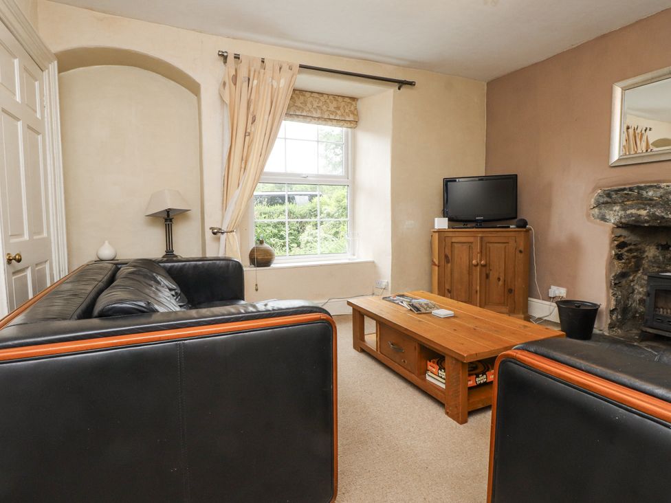 A living room with a television and coffee table at Sygun Cottage in Nant Gwynant