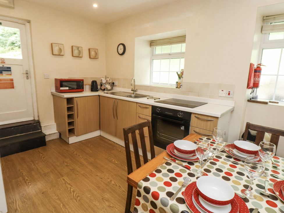 A kitchen with a table set for dining at Sygun Cottage Nant Gwynant