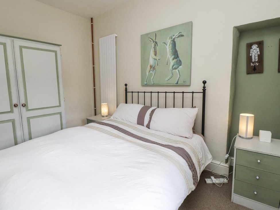 A bedroom with a bed and wardrobe at Sygun Cottage in Nant Gwynant