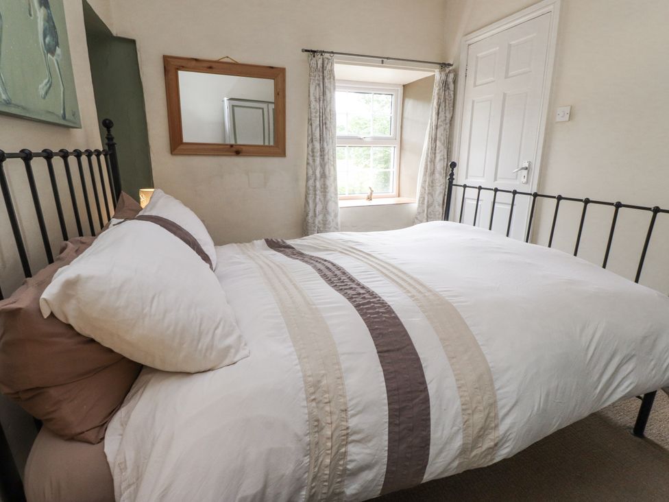 A bedroom with a bed and window at Sygun Cottage in Nant Gwynant
