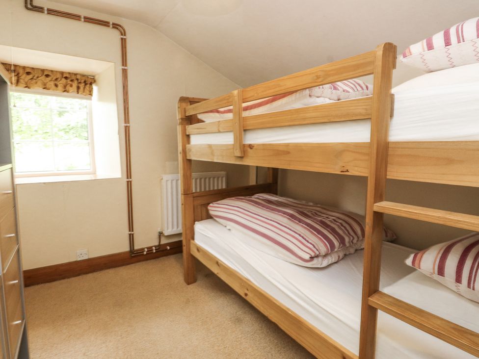 A bedroom with bunk beds and a window at Sygun Cottage in Nant Gwynant