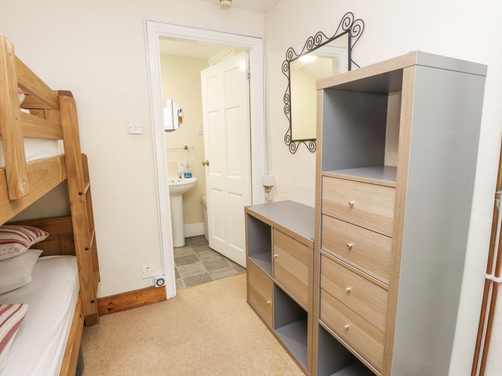 A bedroom with a bunk bed and storage drawers at Sygun Cottage in Nant Gwynant