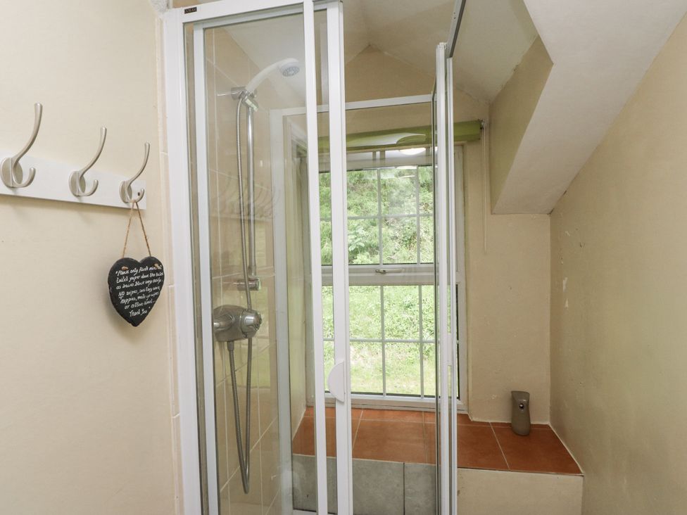 A bathroom with a shower enclosure and window at Sygun Cottage Nant Gwynant