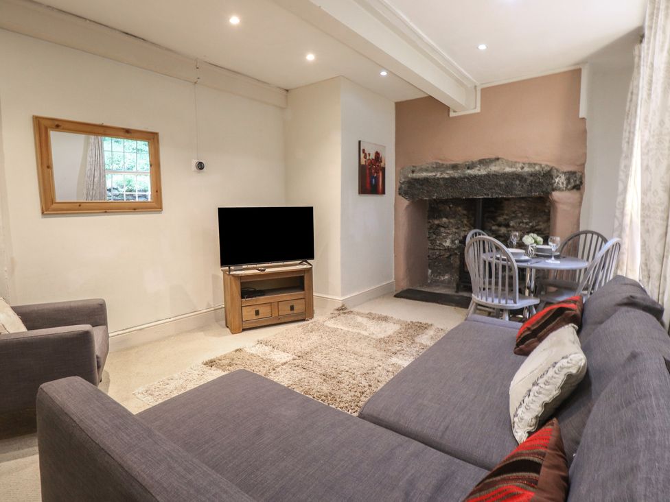 A living room with a TV and a dining area at Tryfan Cottage in Nant Gwynant