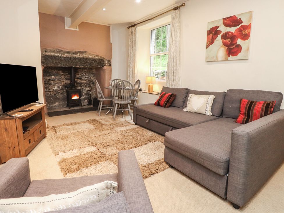 A living room featuring a sofa, tv, and fireplace at Tryfan Cottage in Nant Gwynant