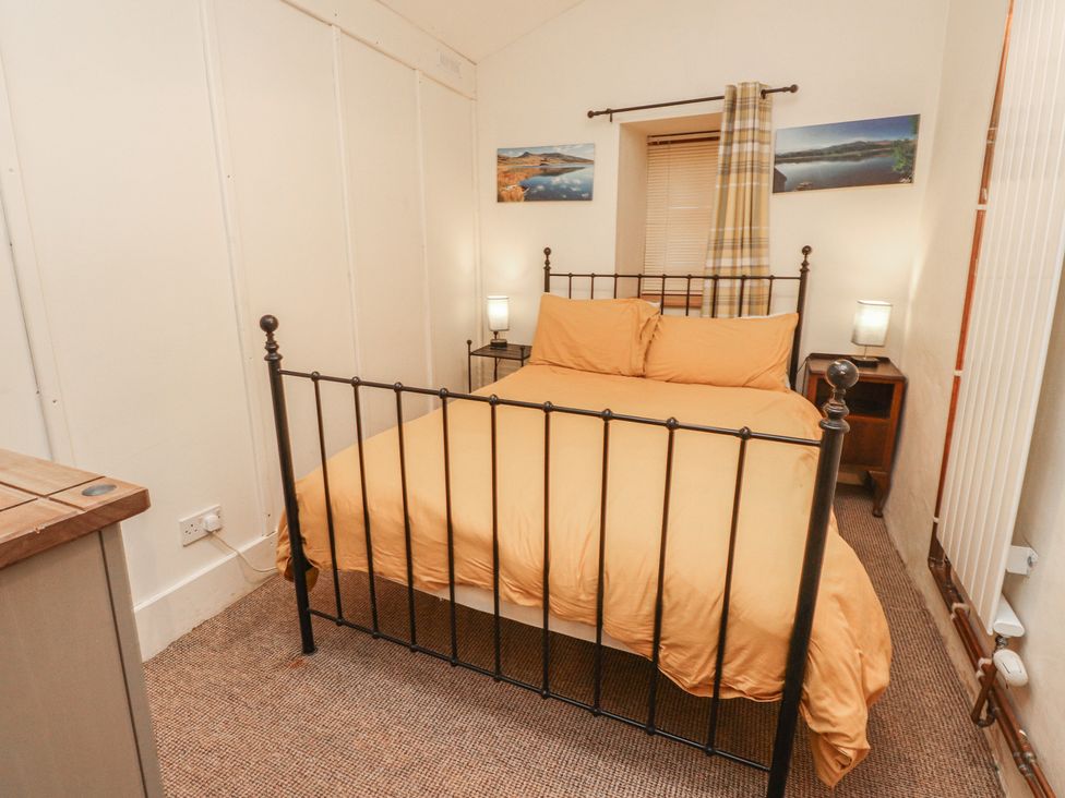 A bedroom with a bed and nightstand at Tryfan Cottage Nant Gwynant