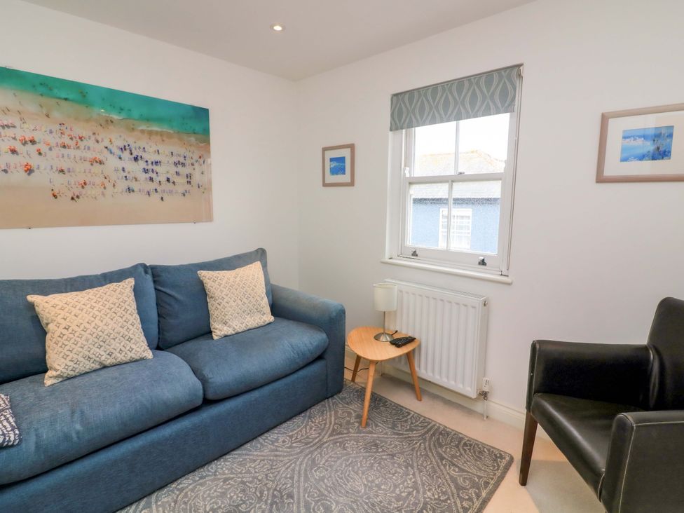 A living room with a sofa and a table at 61B Fore Street in Kingsbridge