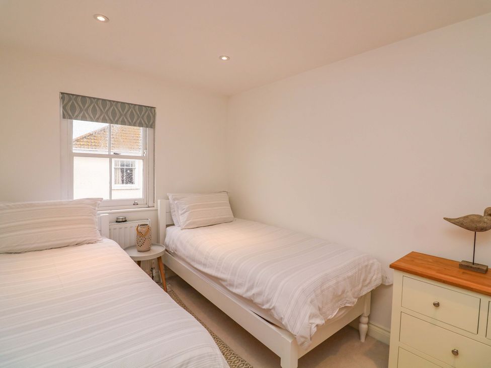 A bedroom with two beds and a window at 61B Fore Street Kingsbridge