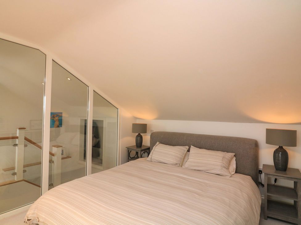 A bedroom with a bed and lamps at 61B Fore Street in Kingsbridge