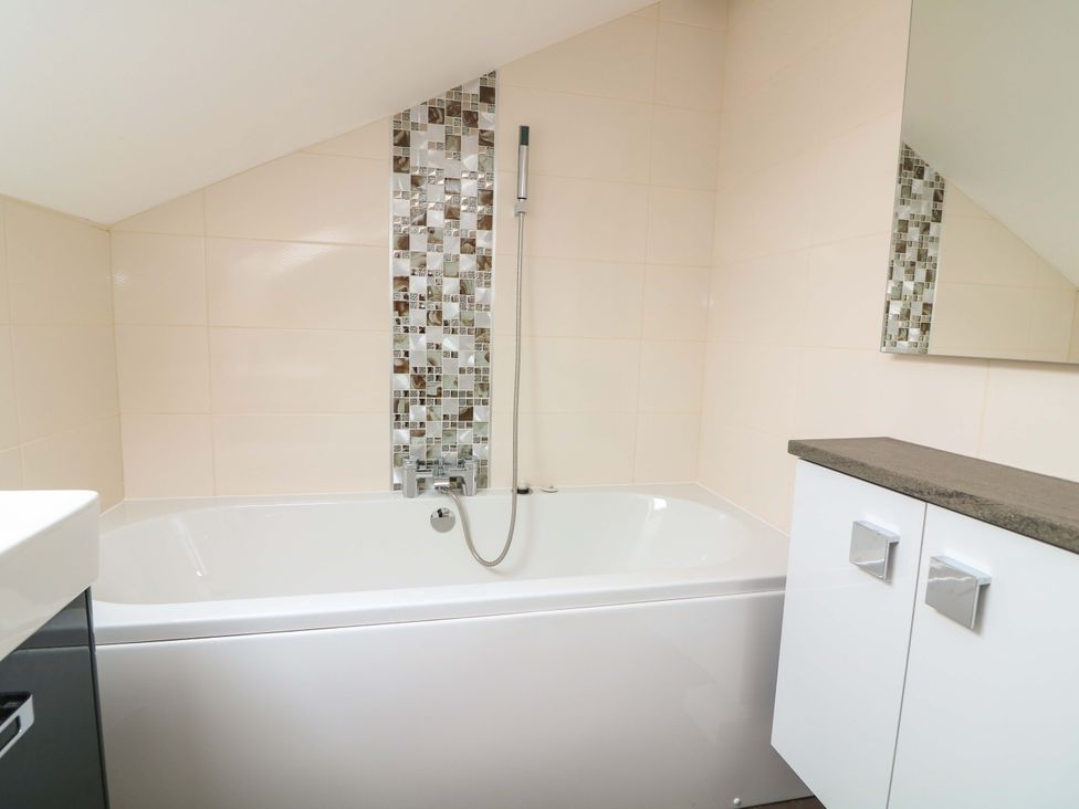 A bathroom featuring a bathtub and showerhead at 61B Fore Street in Kingsbridge