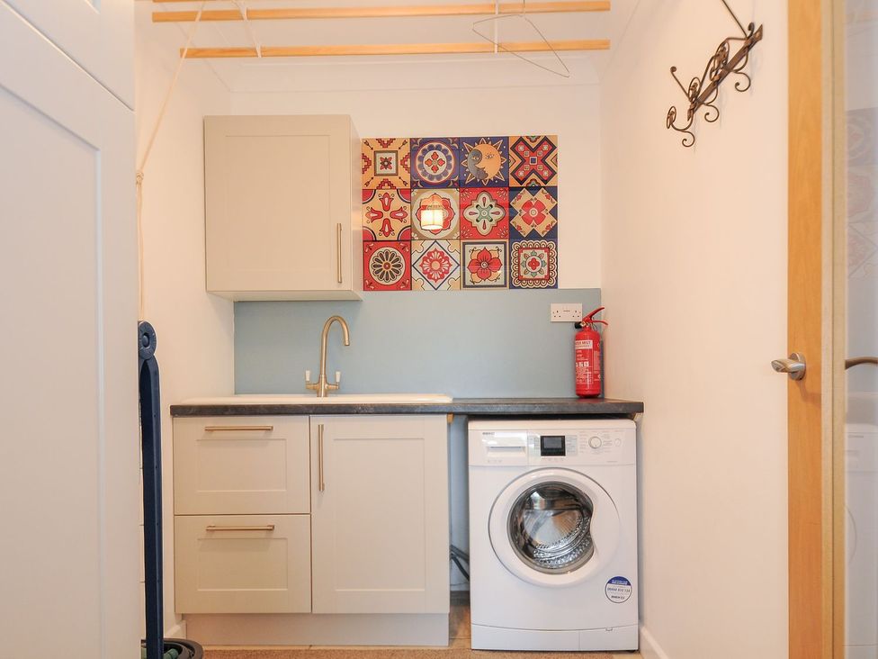 A laundry room with a sink and washing machine at Chimings in Rock