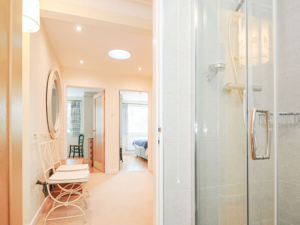 A bathroom with a shower and hallway leading to bedrooms at Chimings Rock