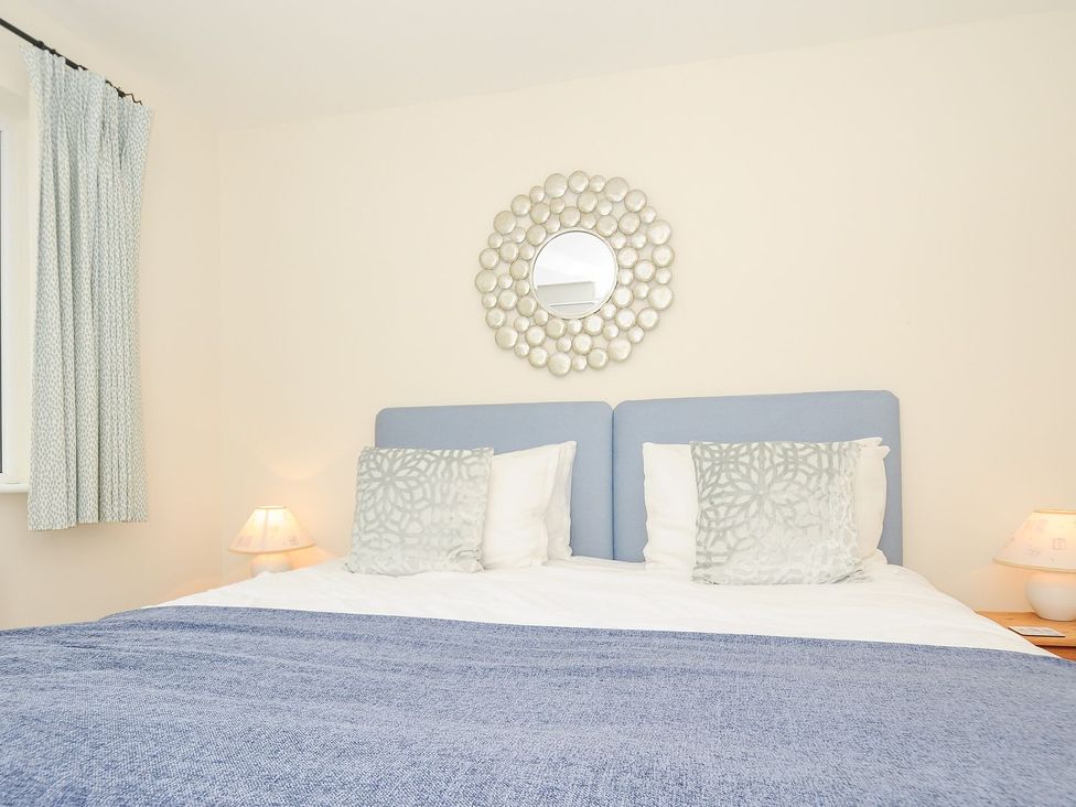 A bedroom featuring a bed with pillows and a lamp at Chimings in Rock