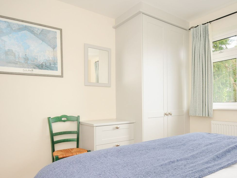 A bedroom with a wardrobe and a chair at Chimings Rock
