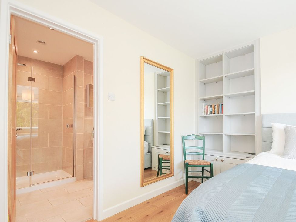 A bedroom with a shower and a mirror at Chimings in Rock