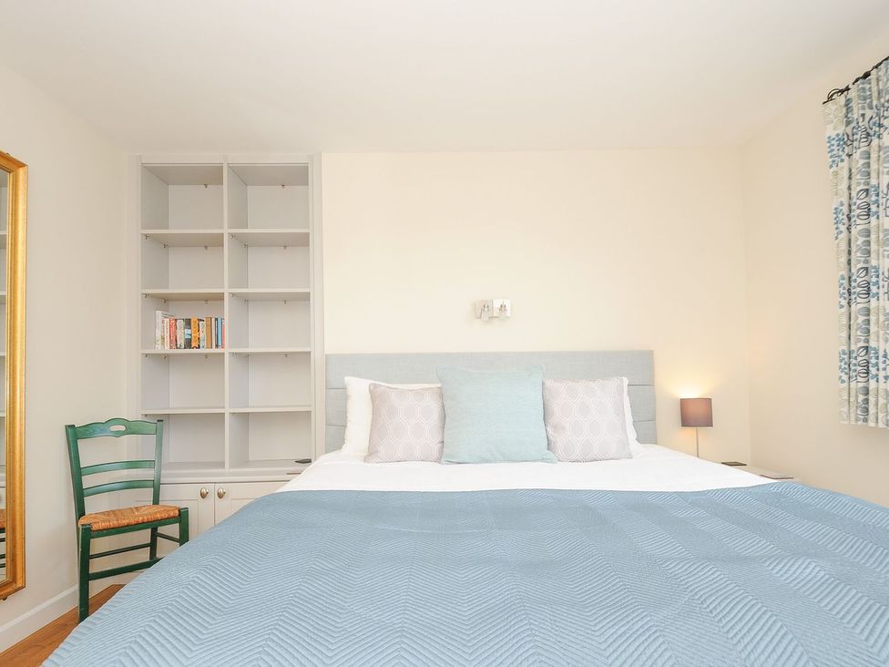 A bedroom with a bed and bookshelf at Chimings in Rock