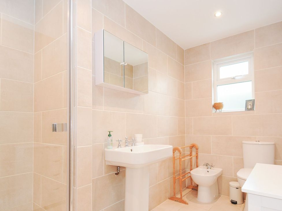 A bathroom with shower, sink, toilet, bidet and mirror at Chimings in Rock