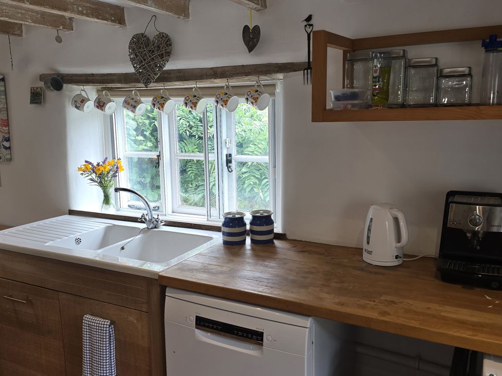 A kitchen with sink, window, and coffee maker at Picket Mead Southleigh near Colyton