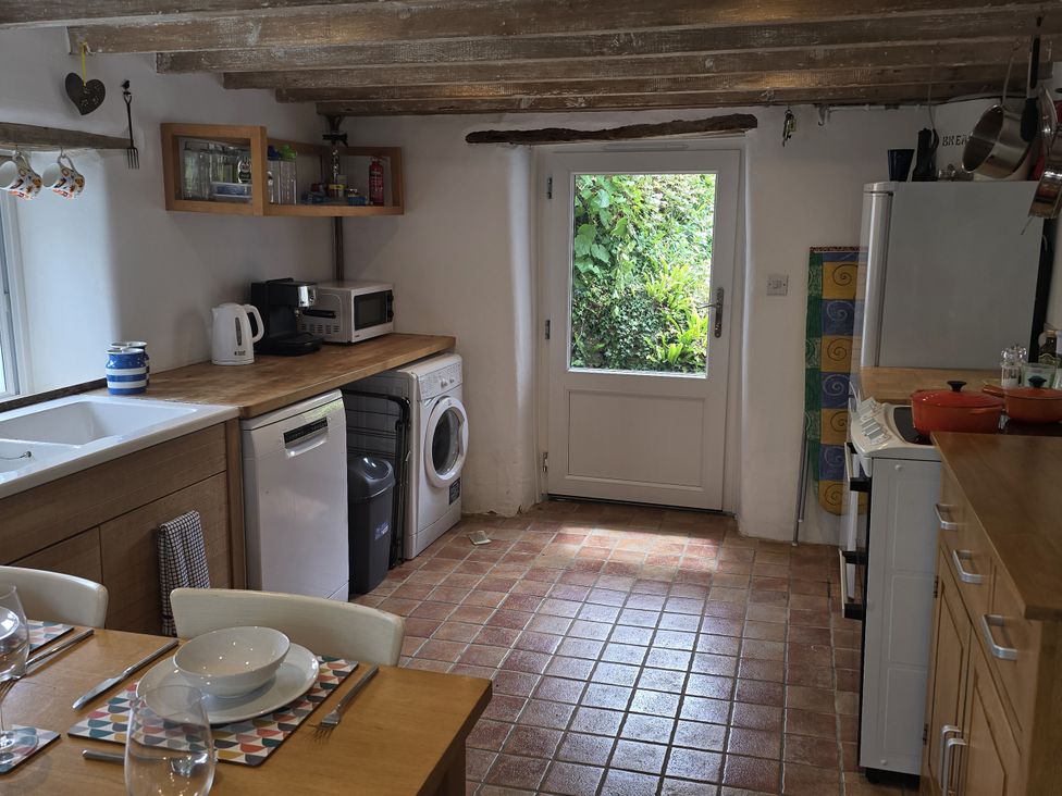 A kitchen with appliances and a door leading outside at Picket Mead Southleigh near Colyton